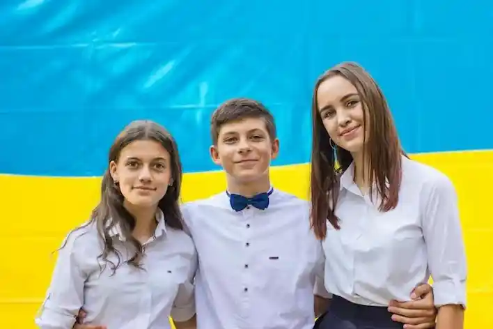 A photograph of three students embracing Culture Day, 2025.