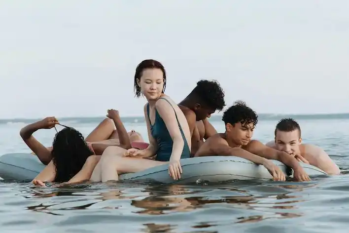 A photograph of teenagers relaxing after participating in a water sports activity.